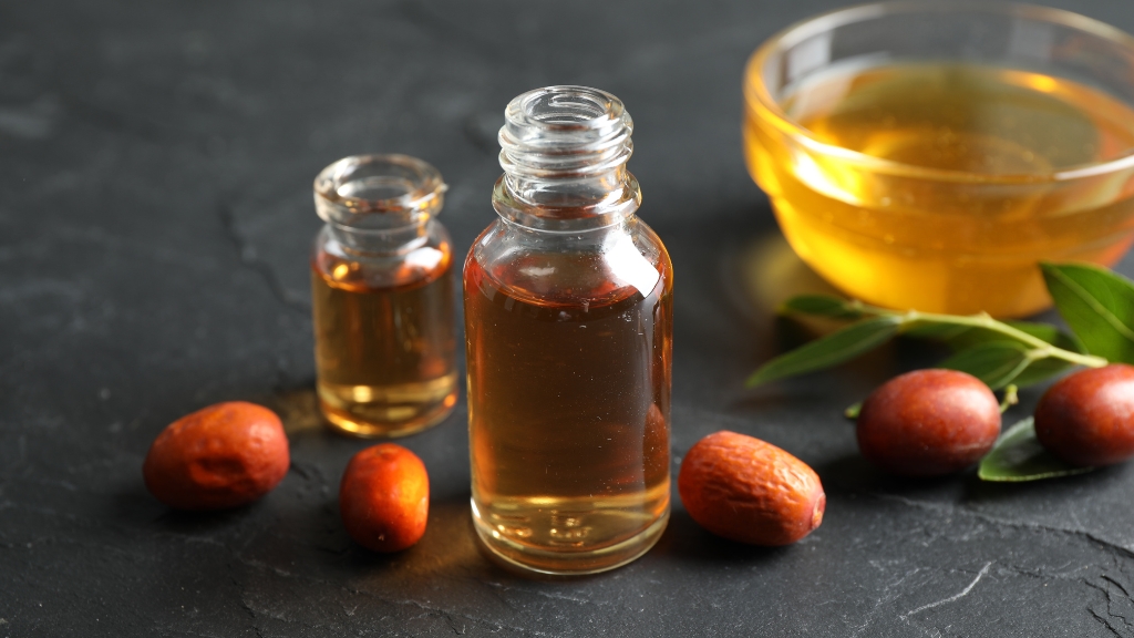 Jojoba ulje u bočicama okruženo plodovima