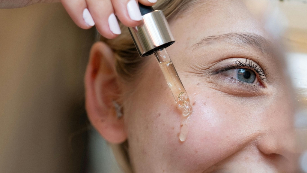 Žena nanosi serum sa niacinamidom na lice pomoću pipete