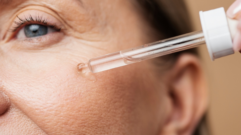 Žena nanosi serum na kožu lica sa vidljivim borama