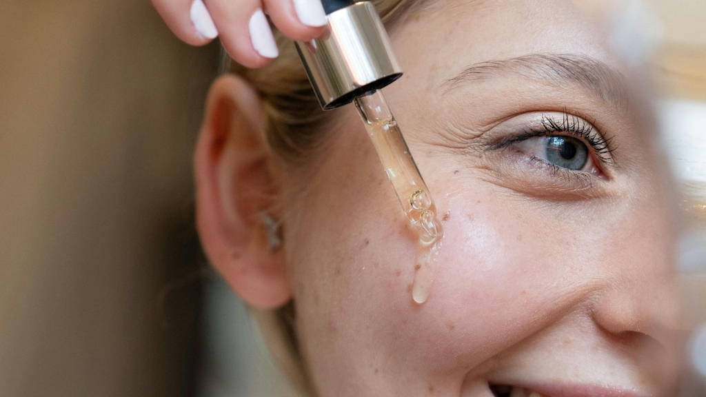 Žena nanosi serum pipetom na lice