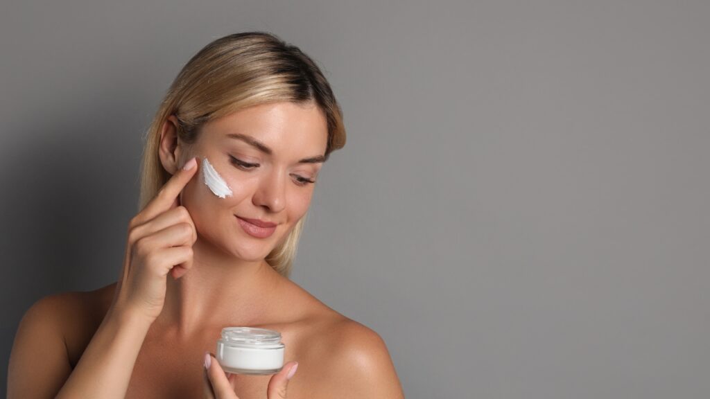 Žena nanosi SPF kremu na lice kao deo svakodnevne jutarnje nege kože