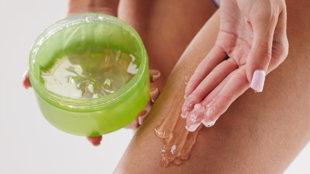 Osoba nanosi aloe vera gel na kožu noge posle depilacije