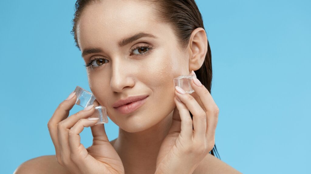 Žena hladi lice kockicama leda tokom ice facial tretmana