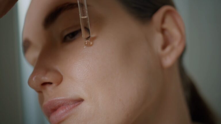 Žena nanosi serum pipetom na lice tokom jutarnje skincare rutine.